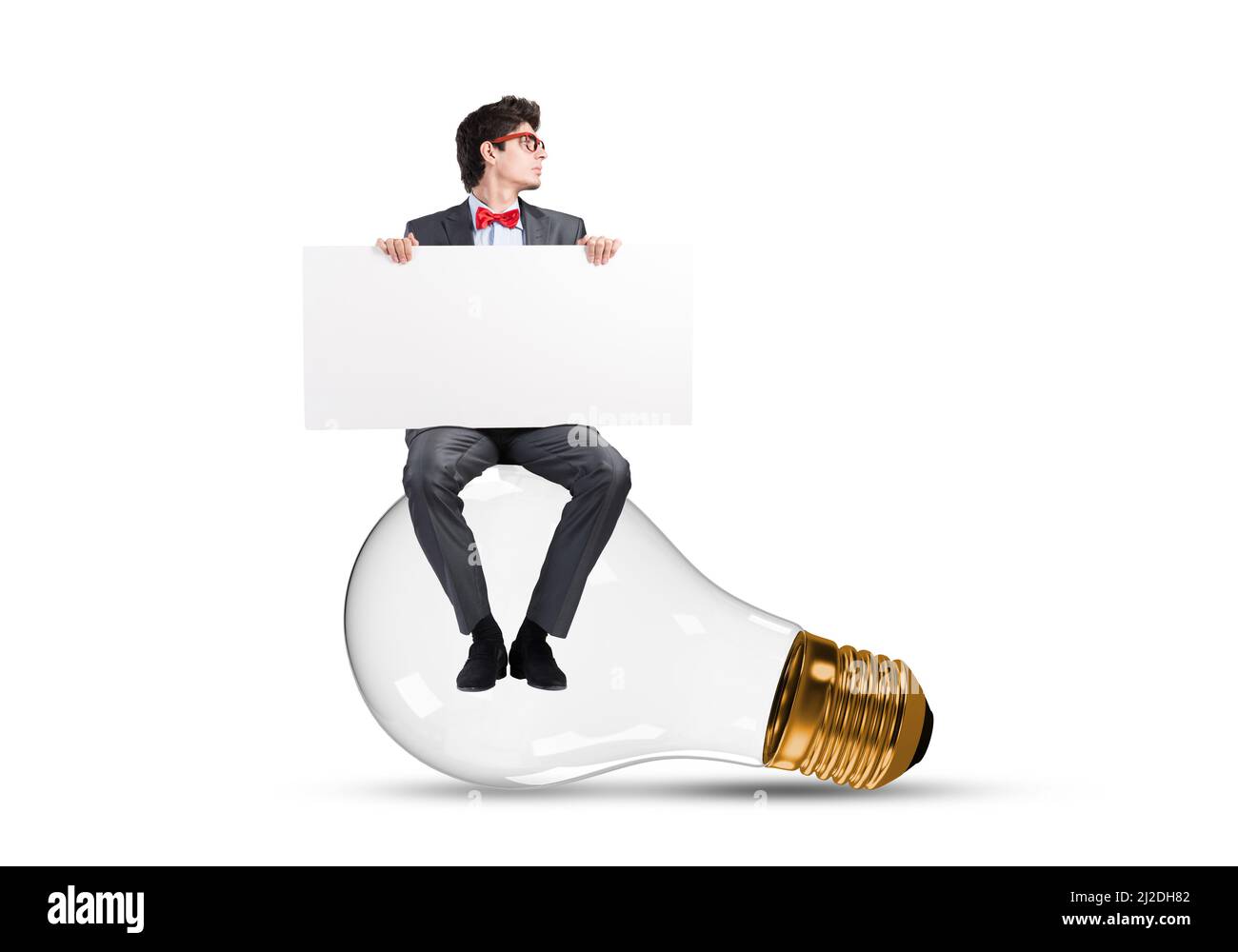 A young businessman sits on a light bulb Stock Photo - Alamy