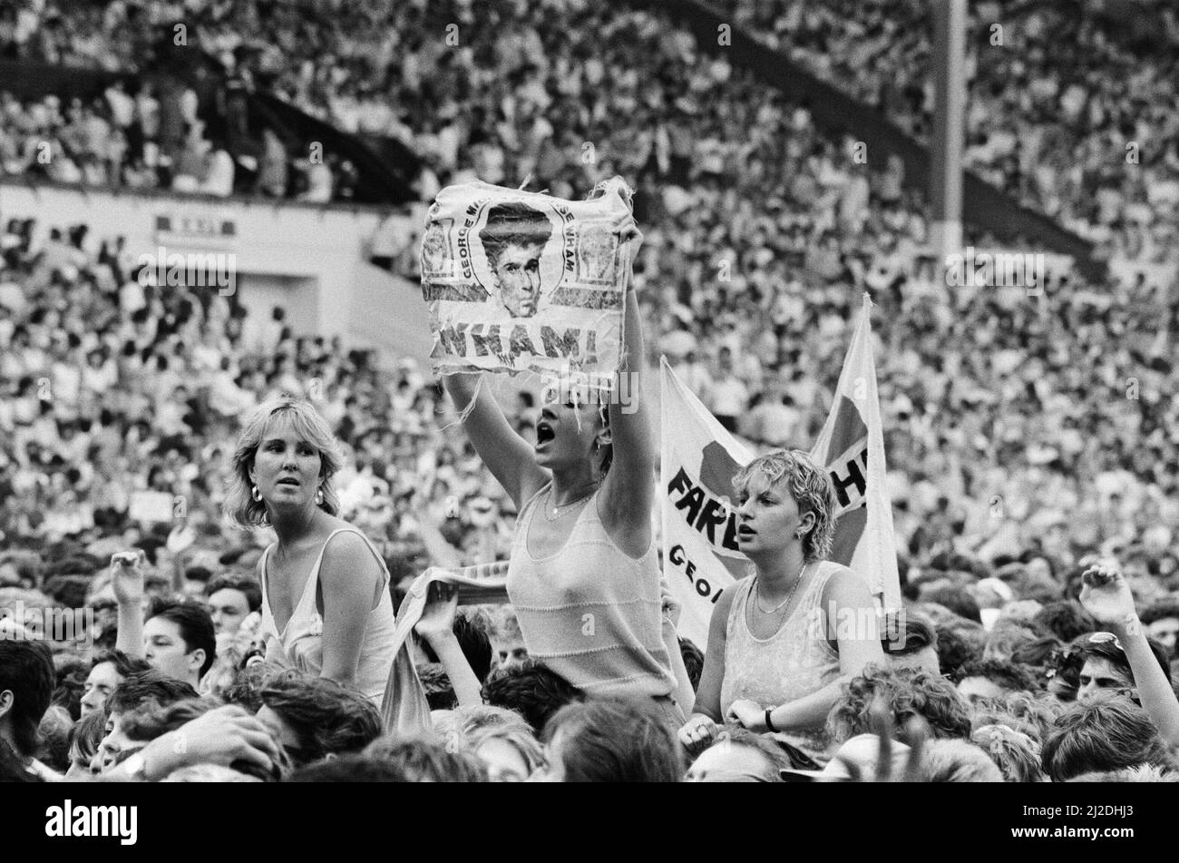 Fans enjoy Wham ! The Farewell Concert at Wembley Stadium, London on 28th June 1986. Wham !,  (singer George Michael, and singer/guitarist Andrew Ridgeley) played their final concert as Wham !, although Andrew joined George as a guest on a few later George Michael solo shows.  Picture taken 28th June 1986 Stock Photo