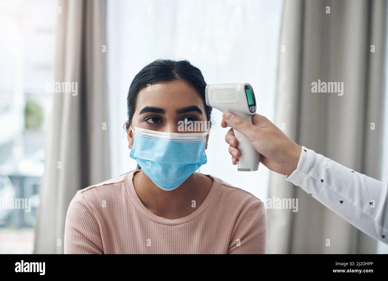 Lets check if you have a fever. Shot of an unrecognizable doctor using