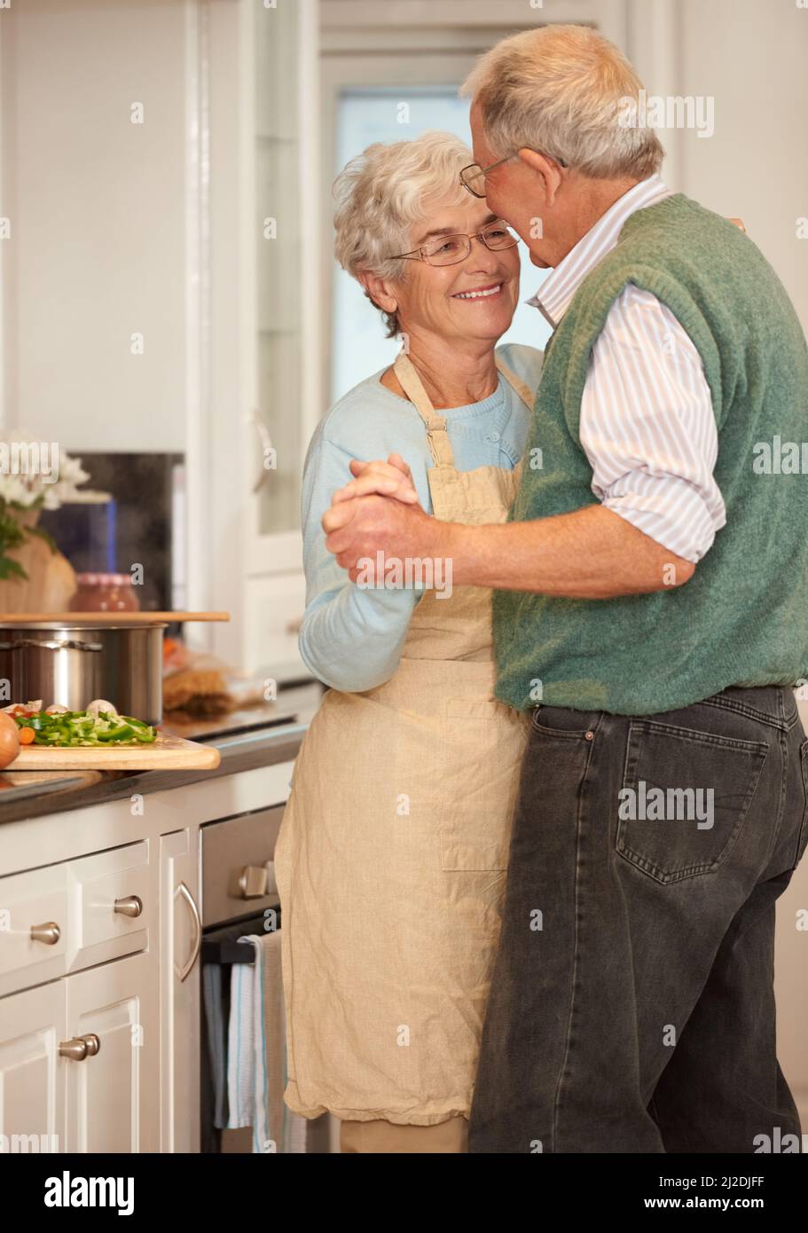 Moments like these are beautiful. Shot of a senior couple enjoying a playful moment together in the kitchen. Stock Photo