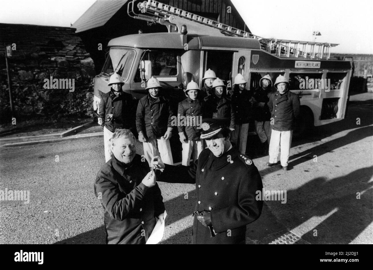 Chief fire officer Dennis Mee hands over the fire engine keys to leading volunteer Ernie Evans.    In 1985, we reported how Holy Island celebrated a landmark in its history with the arrival of its first fire engine.  For Mr Ernie Evans, the islands elected volunteer fire chief, the arrival was the end of several years of waiting.  It means we can at least set about controlling any fires now. And, as well, we have something to practice with and become more efficient, said 64-year-old Mr Evans.  The Holy Island fire engine had been in service at Berwick Fire Station before being taken to the Fir Stock Photo