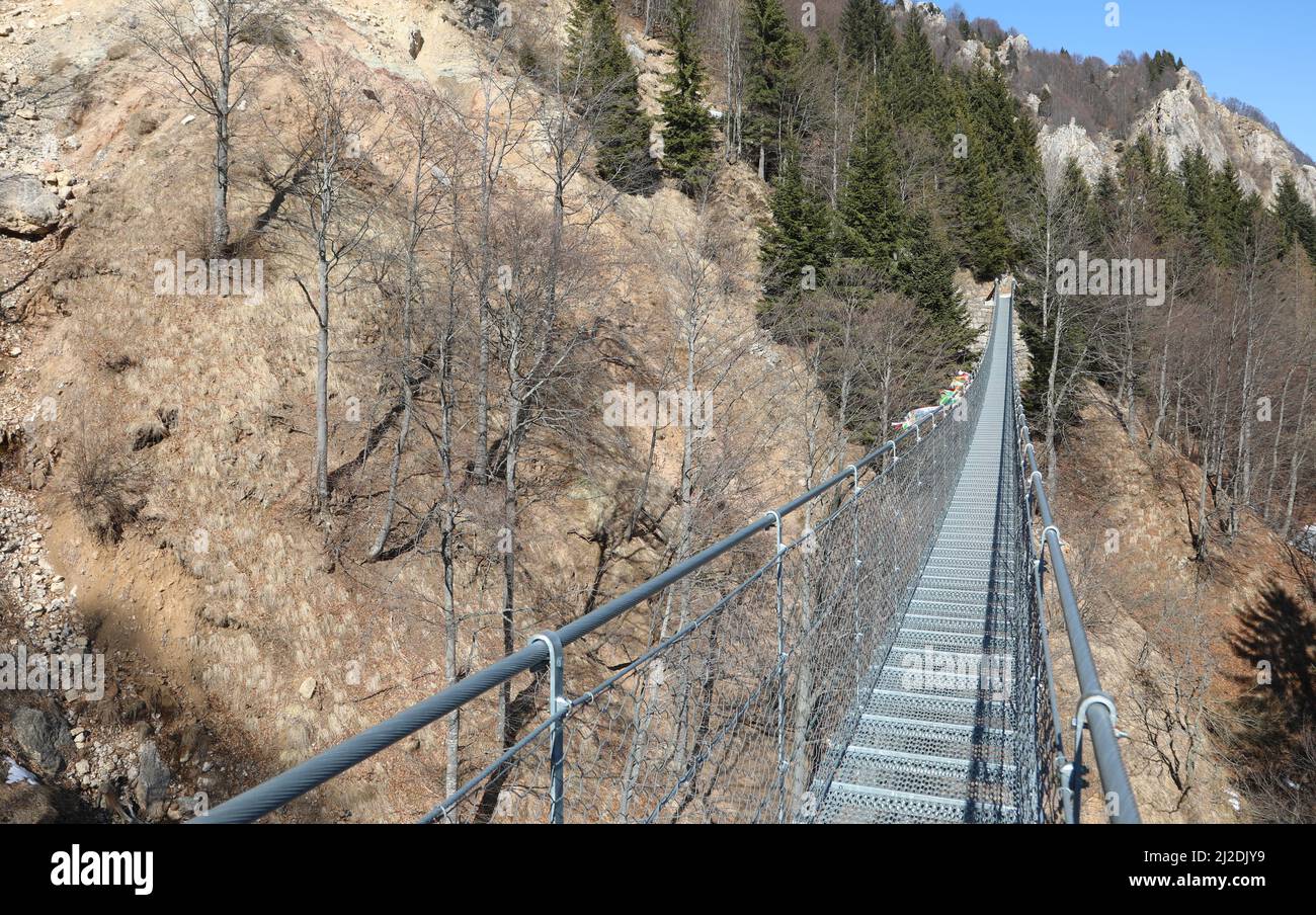 long suspension bridge in stainless steel without people in mountain in Italy Stock Photo
