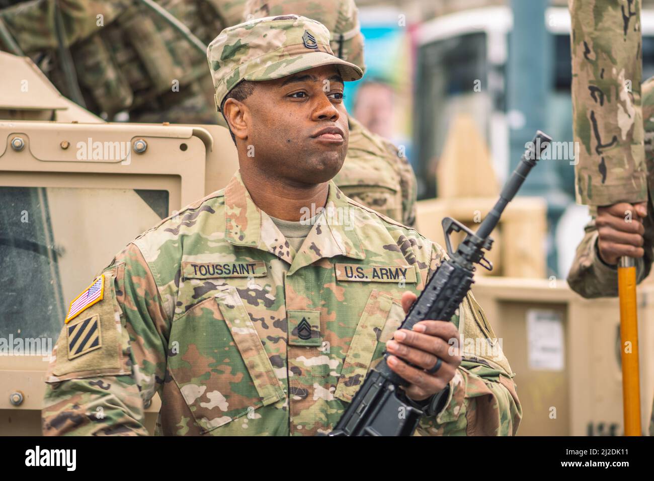 African American United States Marine Corps soldier with shotgun or rifle and armored vehicle humvee on background, USA or US army troops Stock Photo