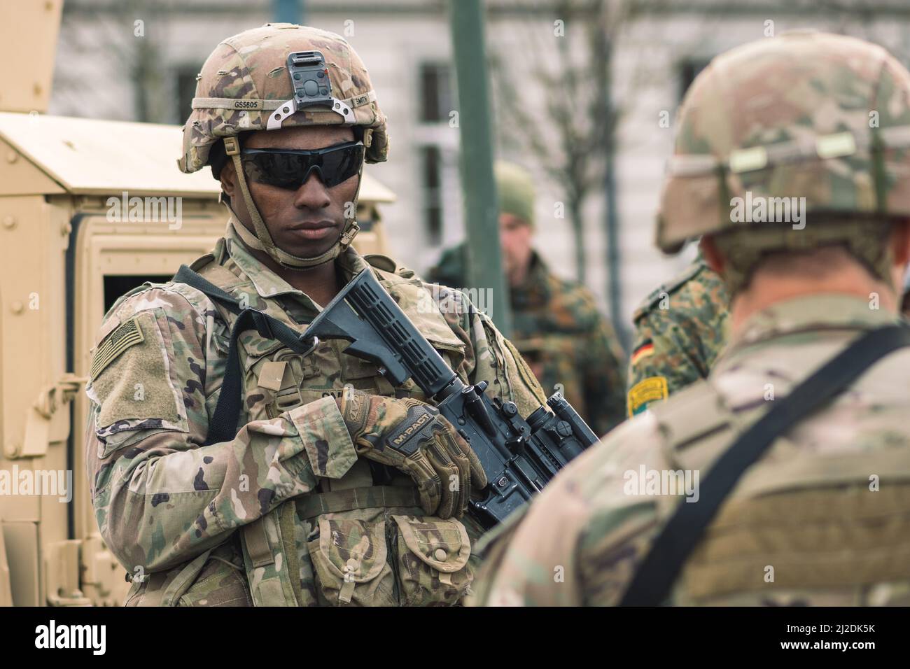 African American United States Marine Corps soldier with sunglasses, shotgun or rifle and armored vehicle humvee, USA or US army troops ready for war Stock Photo