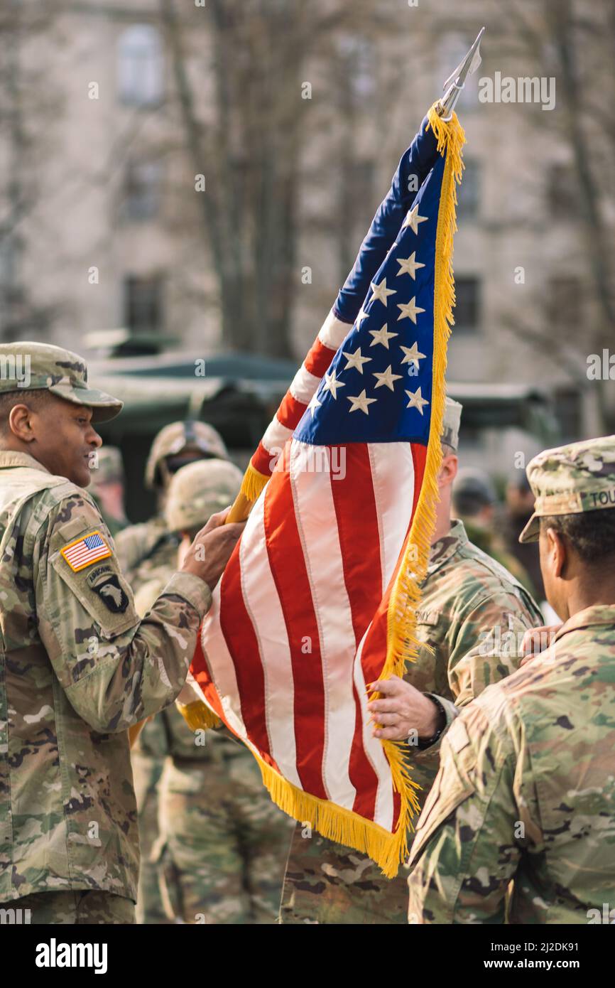 United States Marine Corps soldiers roll up American flag, USA or US army troops ready for drills or war, vertical Stock Photo