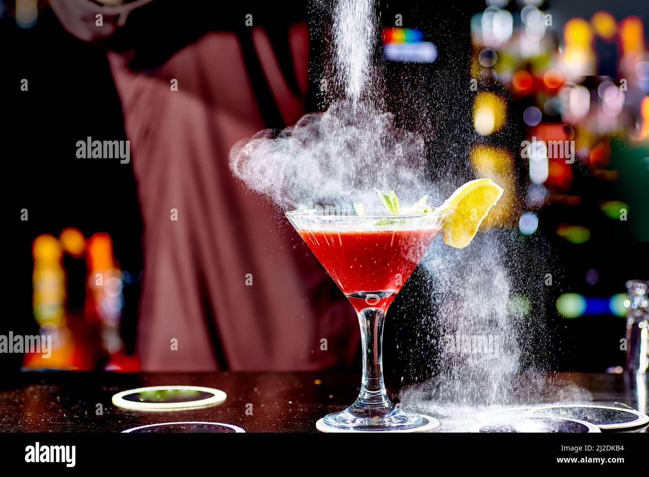 Red cocktail similar to a Margarita covered with powdered sugar is on the bar. Stock Photo