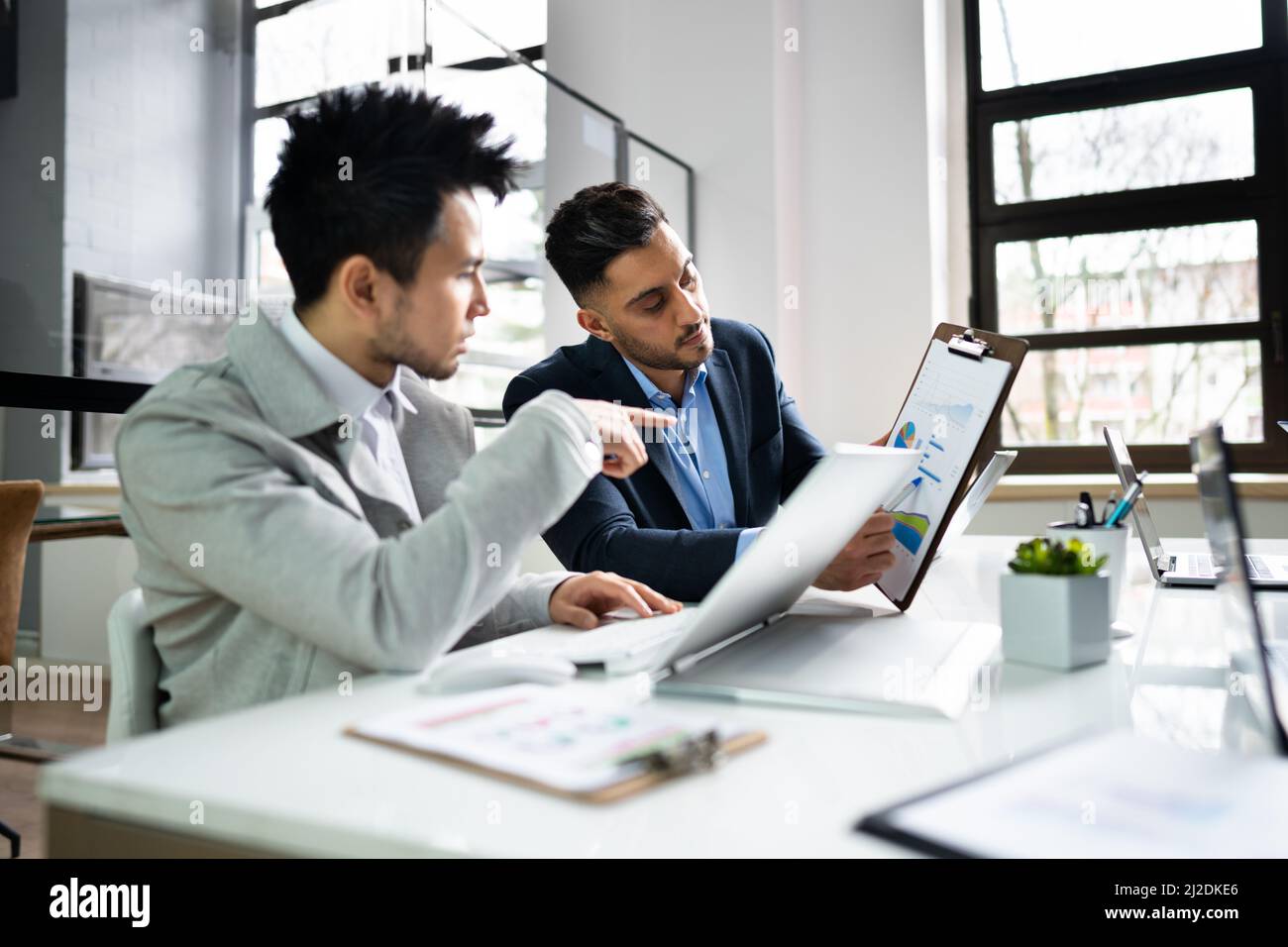 Financial Data Analysts Discussing Business In Office Stock Photo