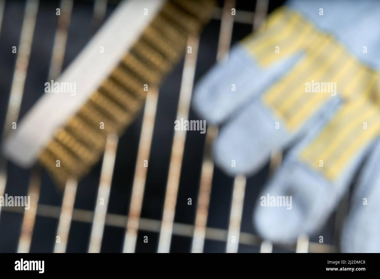 Dirty grill grate with cleaning tool. Leather glove and wooden wire