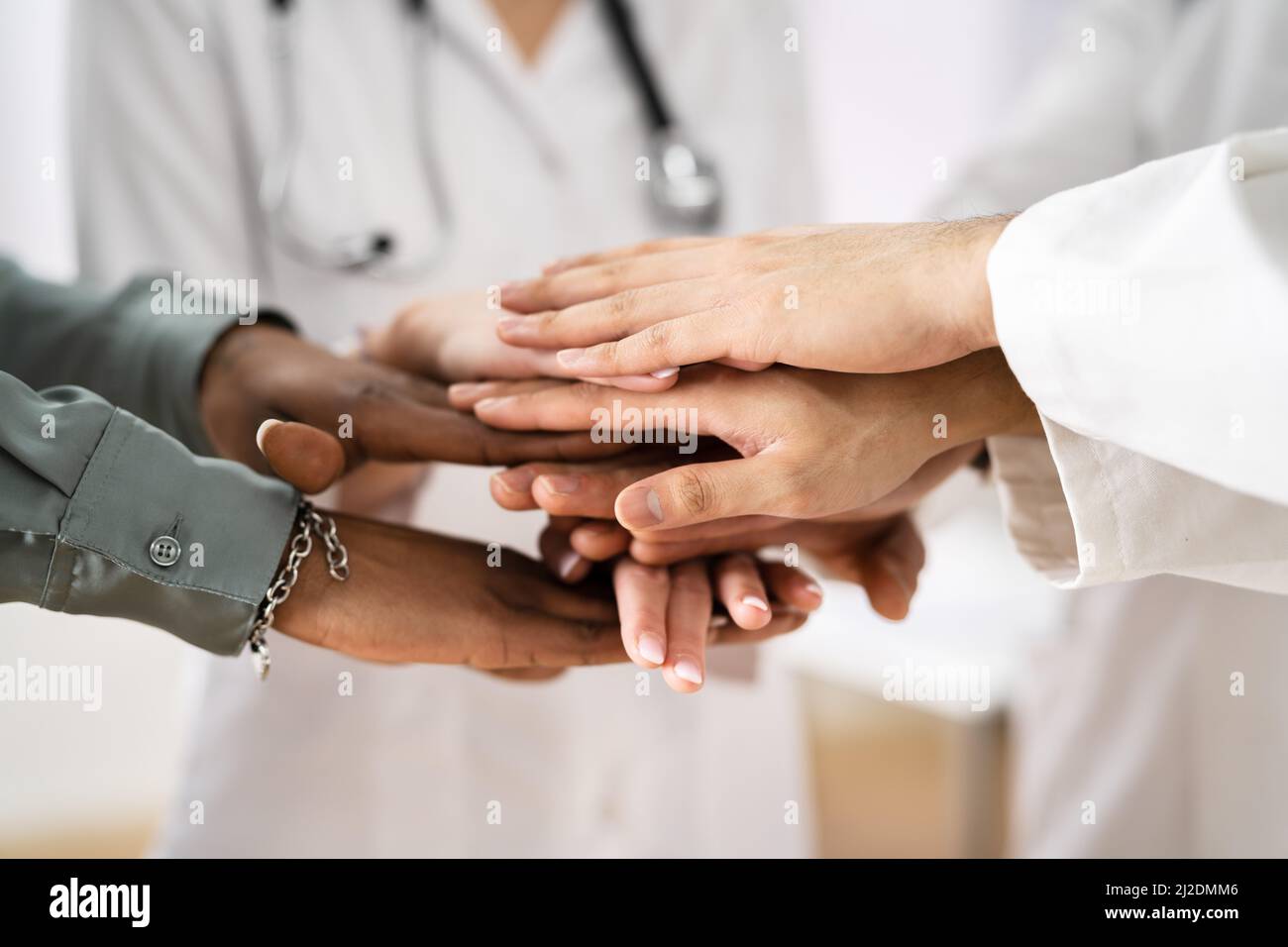 Medical Team Stacking Hands Against In Hospital Stock Photo