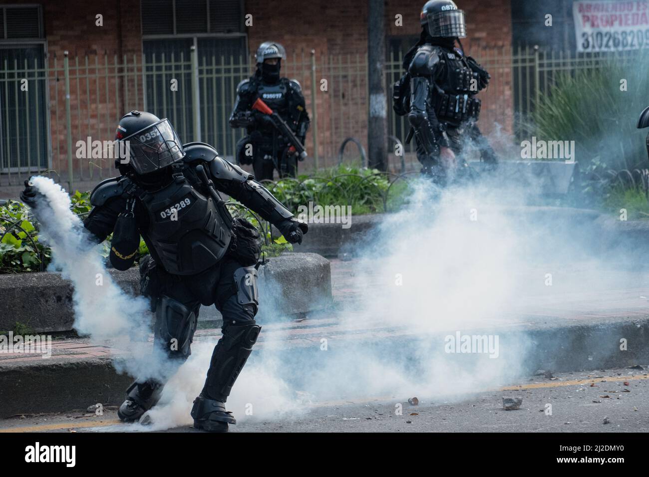 A Colombia's riot police officer throws back a tear gas canister as students protested against Colombia's national police and government on March 31, 2022 in Bogota, Colombia. As demonstrators and Colombia's riot police squad 'ESMAD' ended up in clashes in northern Bogota. Photo by: Daniel Romero/Long Visual Press Stock Photo