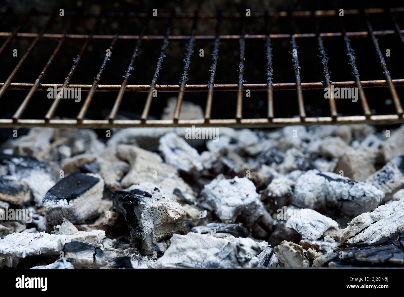 Glowing charcoal and grill grate. Dirty barbecue rust after cooking