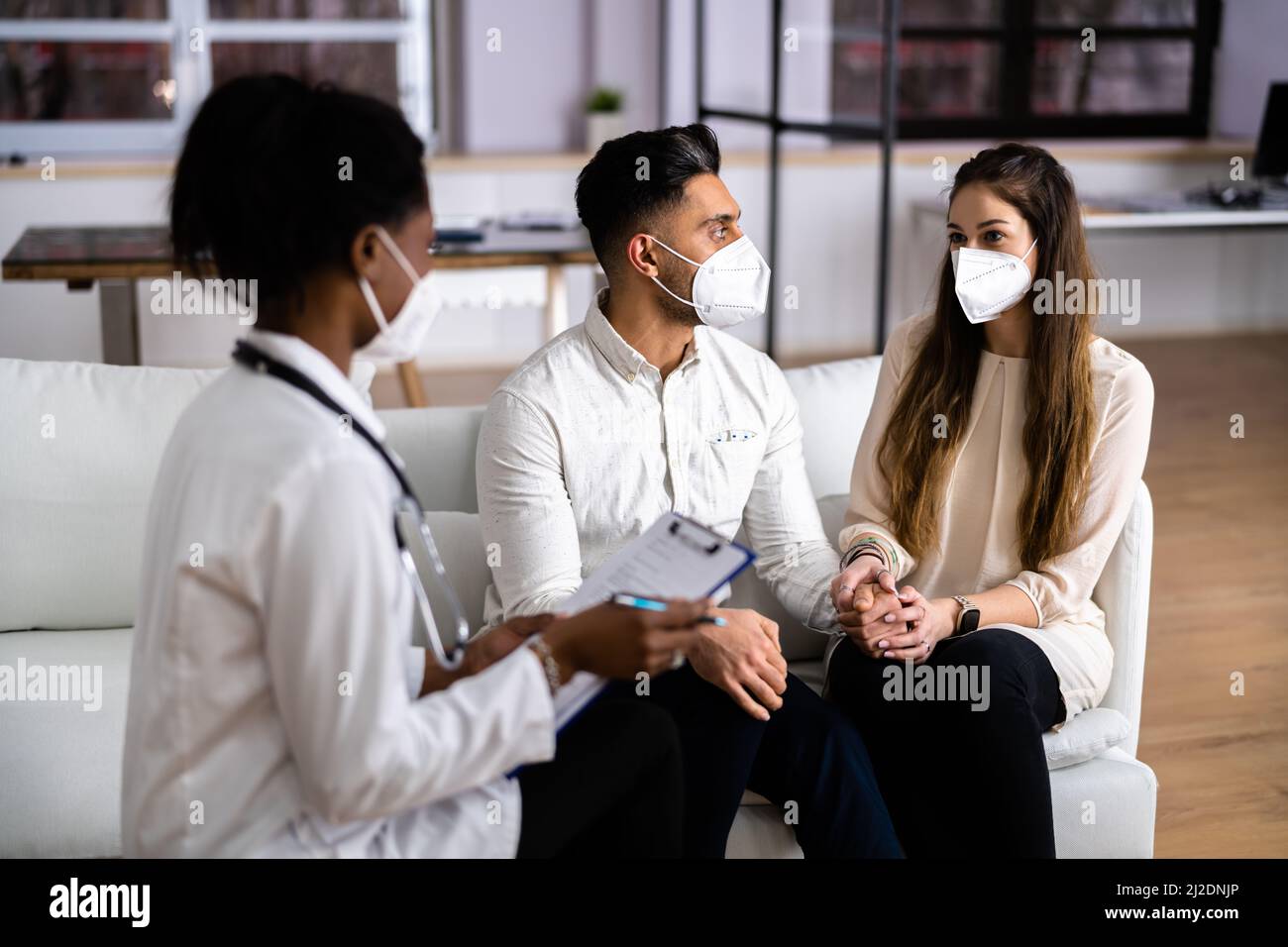 Pregnant Couple And Medical Doctor At Home Pregnancy test Stock Photo