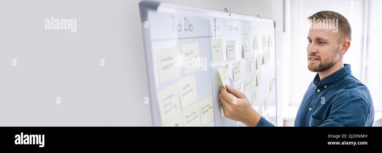 Man Writing Kanban Plan On Wall Board Stock Photo