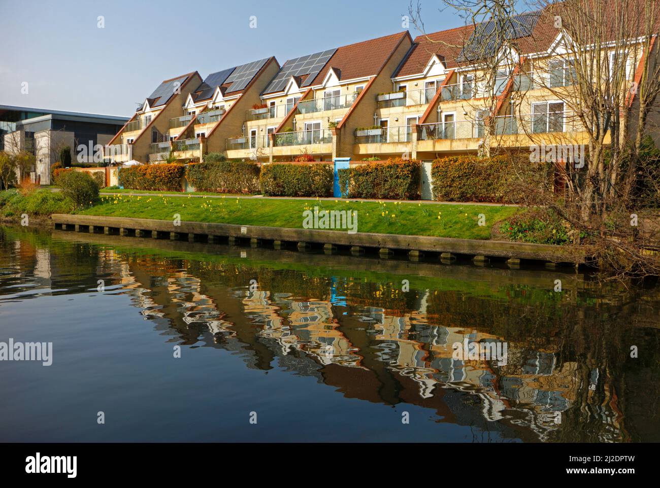 A modern build of flats by the River Wensum with reflections in the river off Barrack Street in the City of Norwich, Norfolk, England, UK. Stock Photo