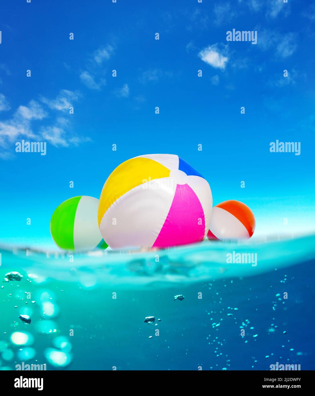 Inflatable balls float in water, split underwater sea image Stock Photo