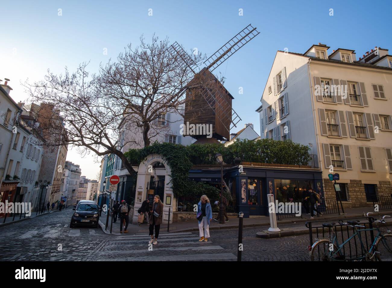 Paris, France - March 22, 2022 : A French restaurant bar with a windmill at the top in the picturesque area of Montmartre Paris at day time Stock Photo