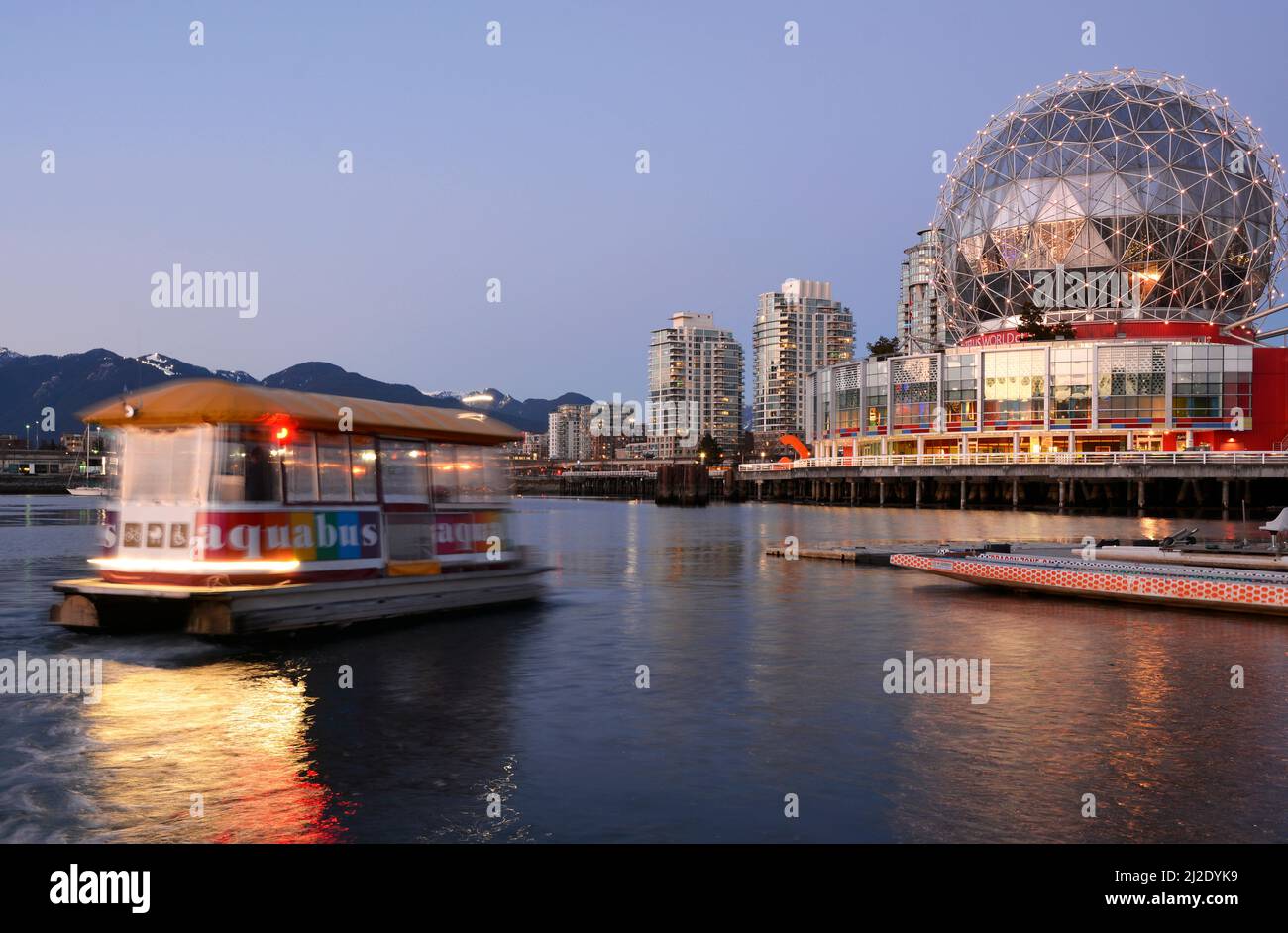 Aquabus passenger ferry travelling towards Telus World of Science on False Creek in Vancouver at dusk. Stock Photo