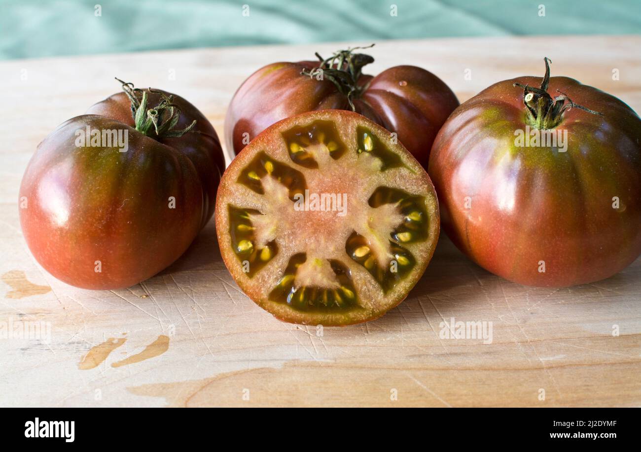 Delicious Black Krim heirloom tomatoes on a wood cutting board. Stock Photo