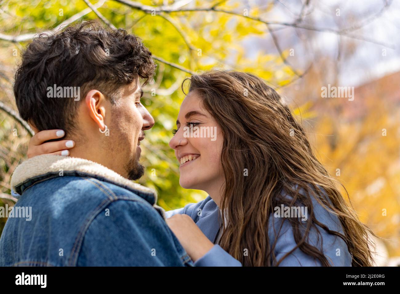 A loving couple smiling and looking at each other in a park Stock Photo
