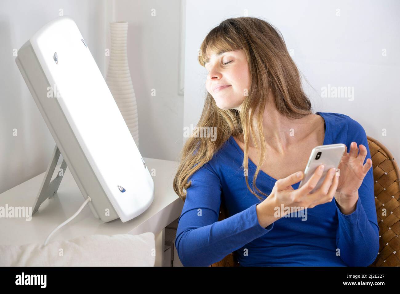 Woman smartphone light therapy Stock Photo
