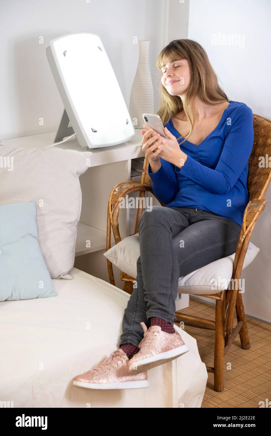 Woman smartphone light therapy Stock Photo