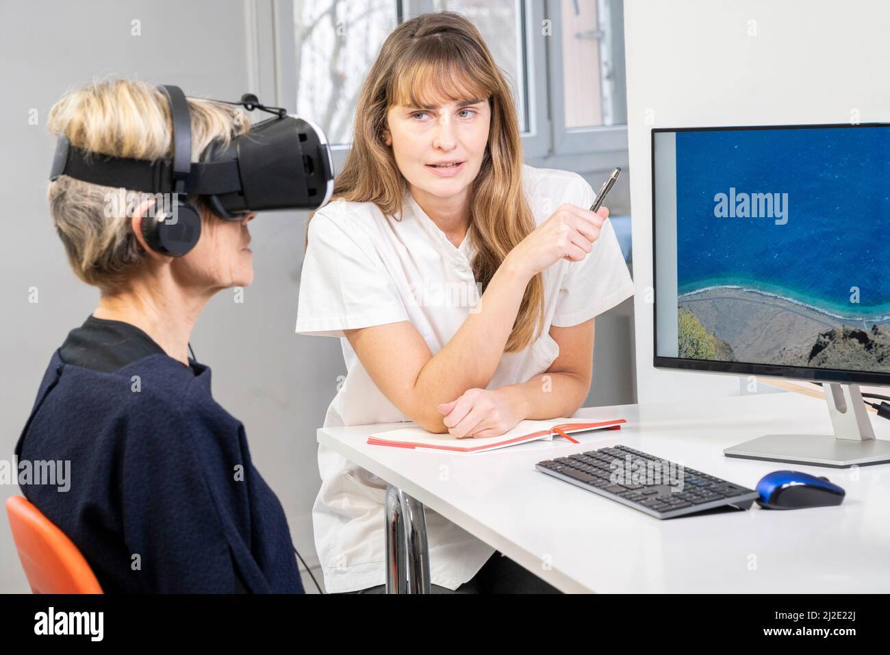 Elderly woman in virtual reality headset Stock Photo