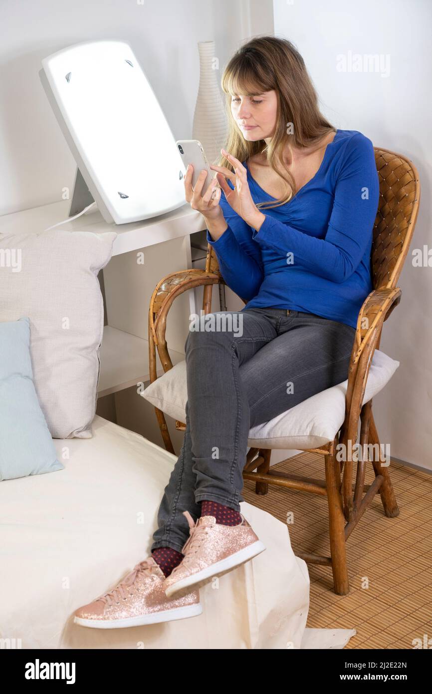 Woman smartphone light therapy Stock Photo