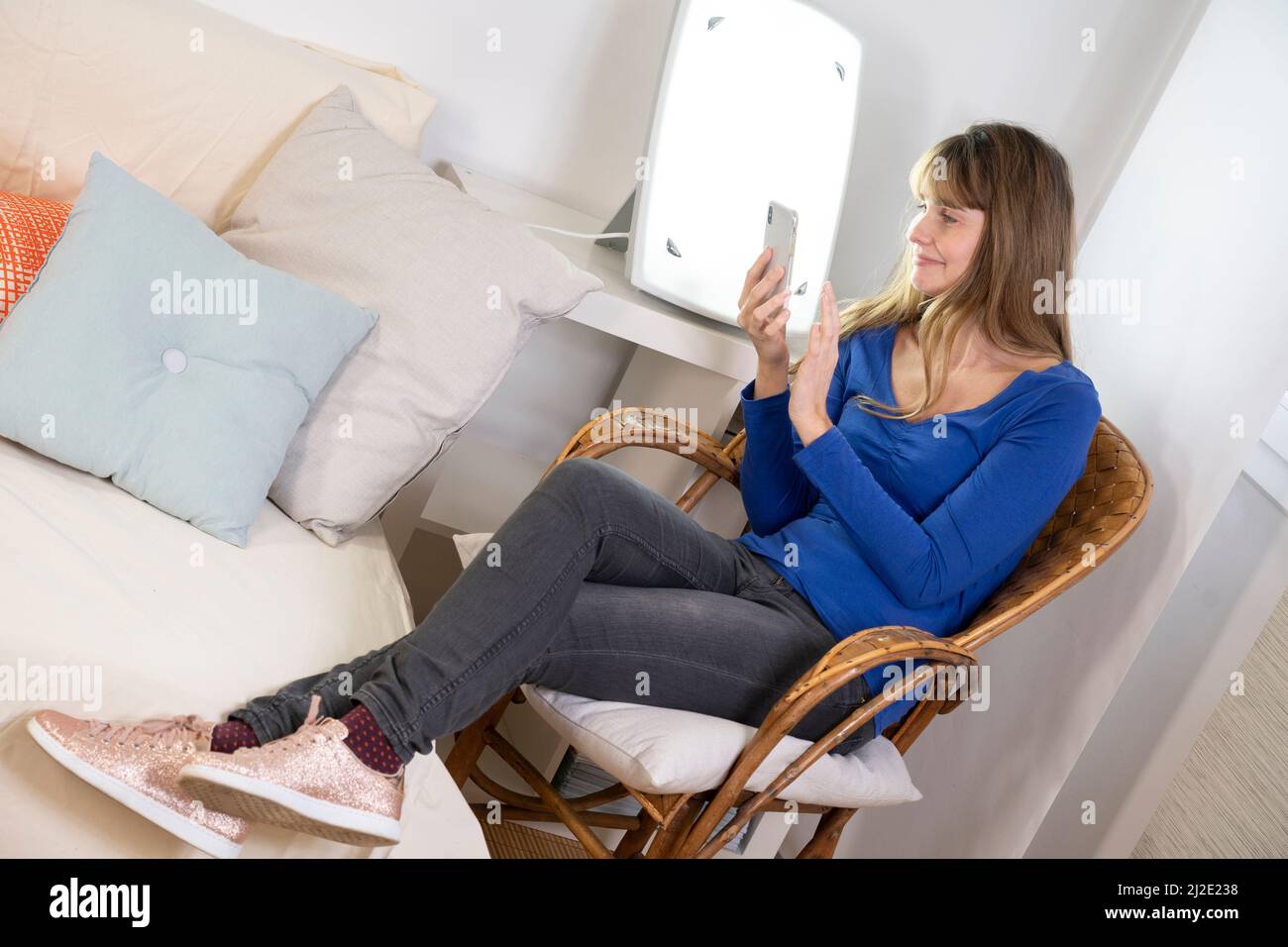 Woman smartphone light therapy Stock Photo
