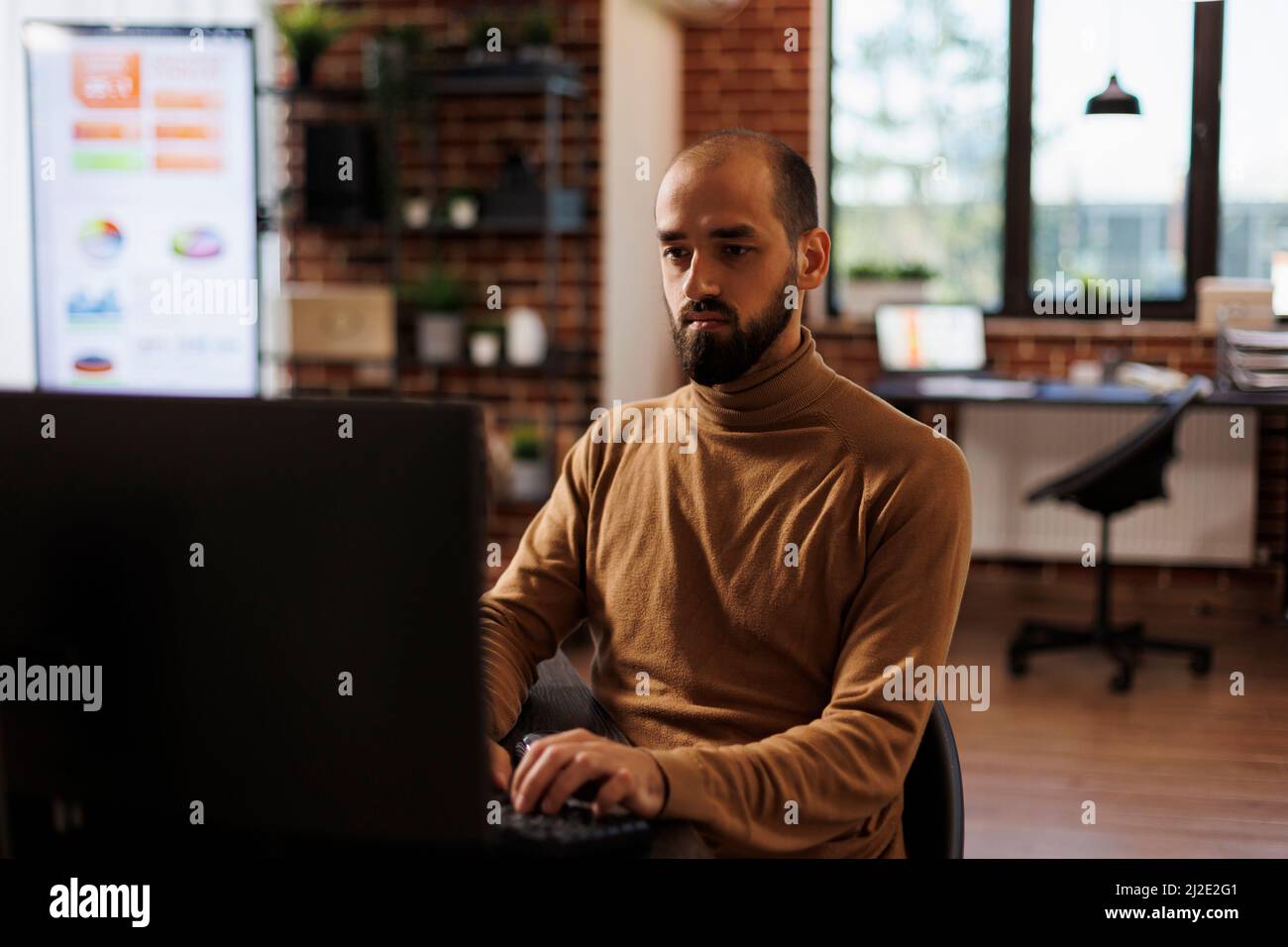 Development agency office worker analyzing project sales and fintech startup. Businessperson sitting at desk in marketing company office developing financial strategy and accounting management. Stock Photo