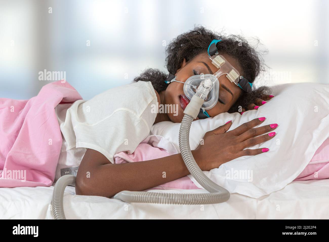 Woman wearing cpap headgear to sleep against apnea Stock Photo