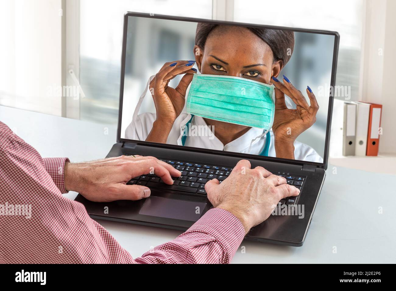 Virology protective concept. close up of senior man sit at home having online consultation with female nurse on how using proctective mask Stock Photo