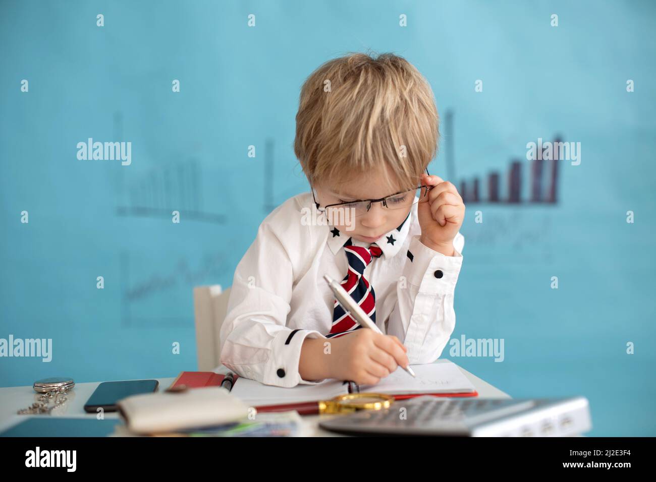 Boy Opening Note Good looking, smart casual dressed child, blond boy with tie, working ...