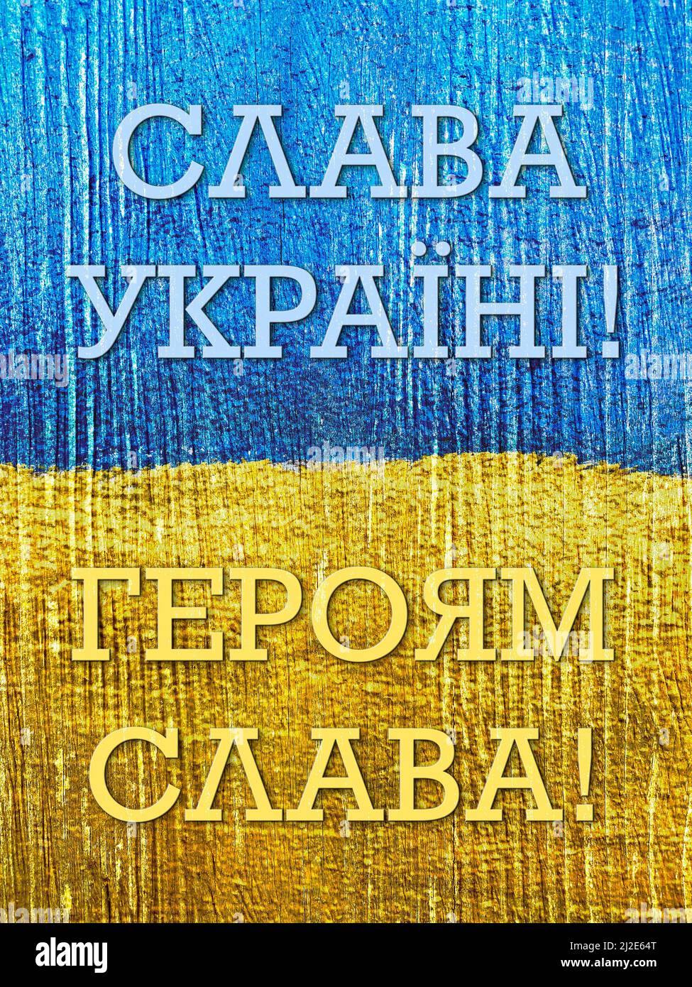 message Glory to Ukraine, Glory to Heroes in Ukrainian on flag painted on wooden wall Stock Photo