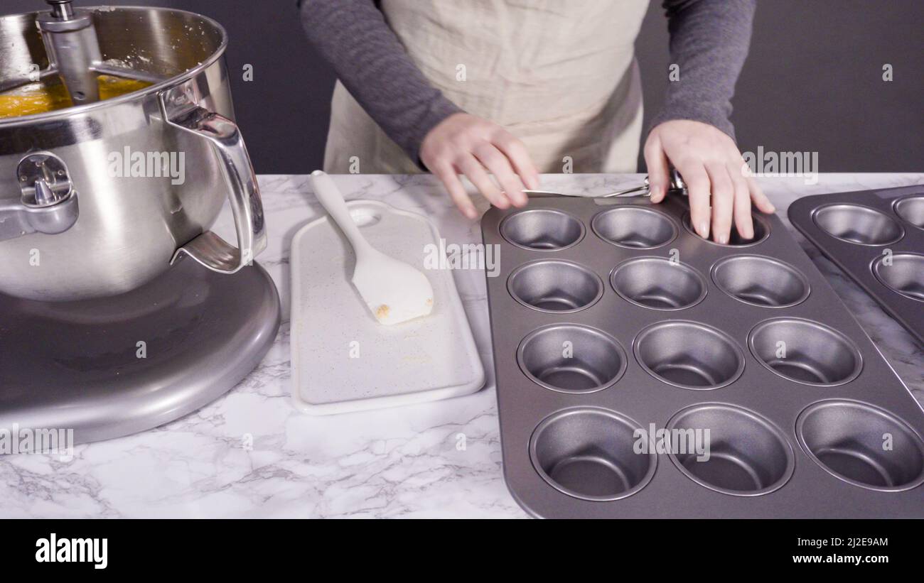 Scooping pumpkin spice cupcake batter with batter scoop into a cupcake