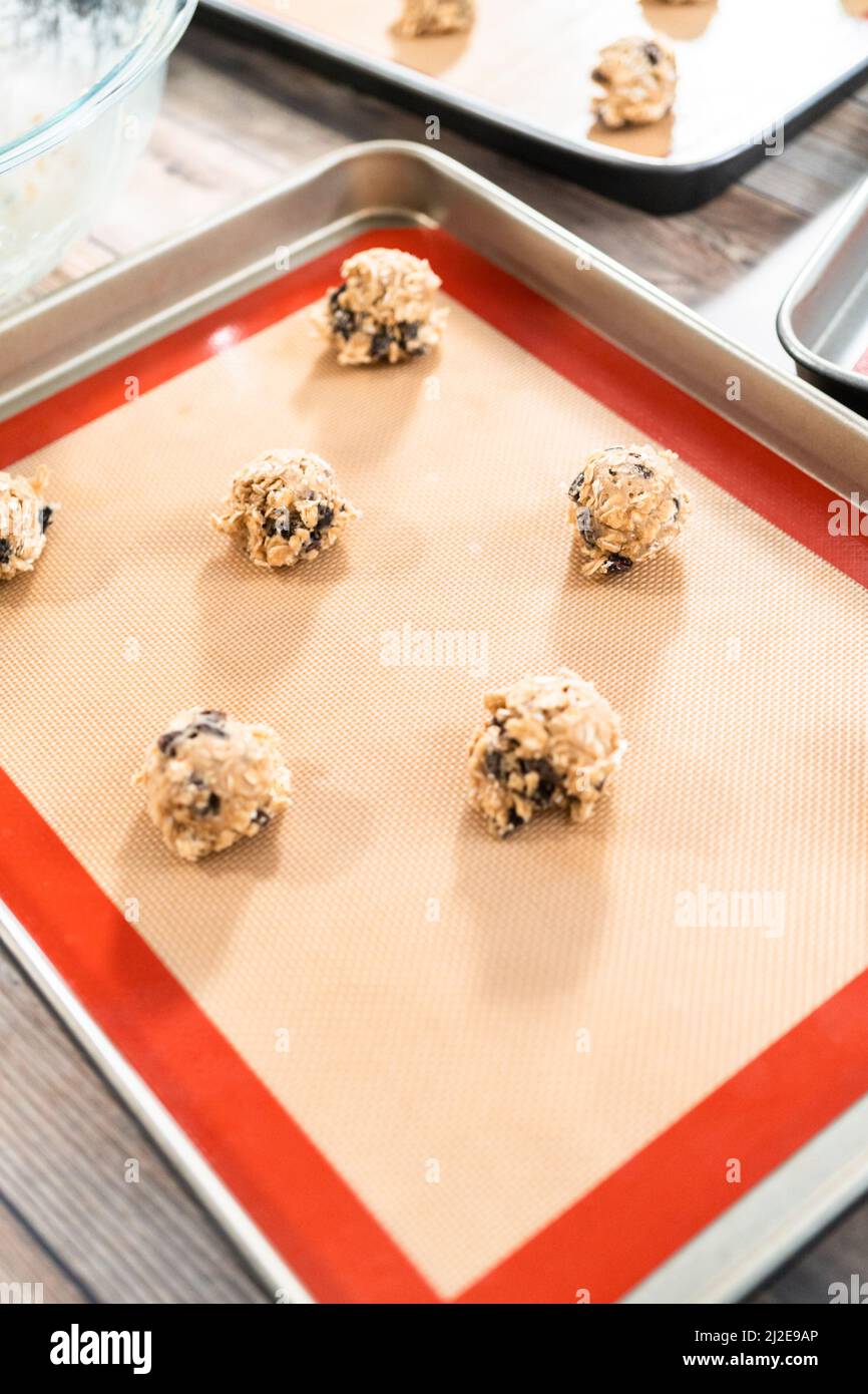 Scoops of cookie dough on a baking cheets to bake chewy oatmeal raisin cookies Stock Photo Alamy