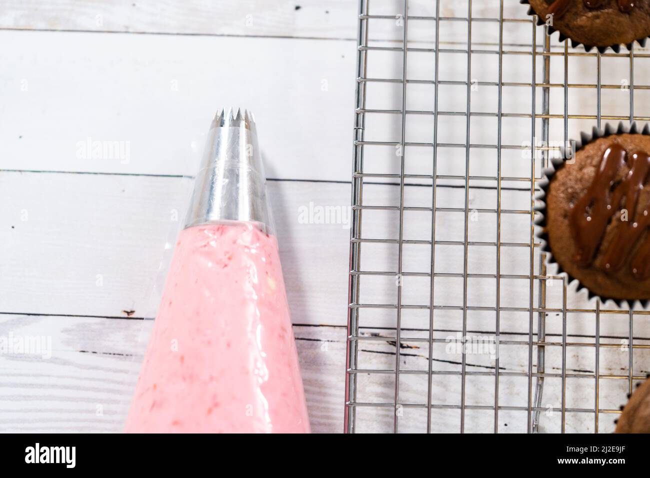 Raspberry cream cheese frosting in a piping bag with metal tip Stock
