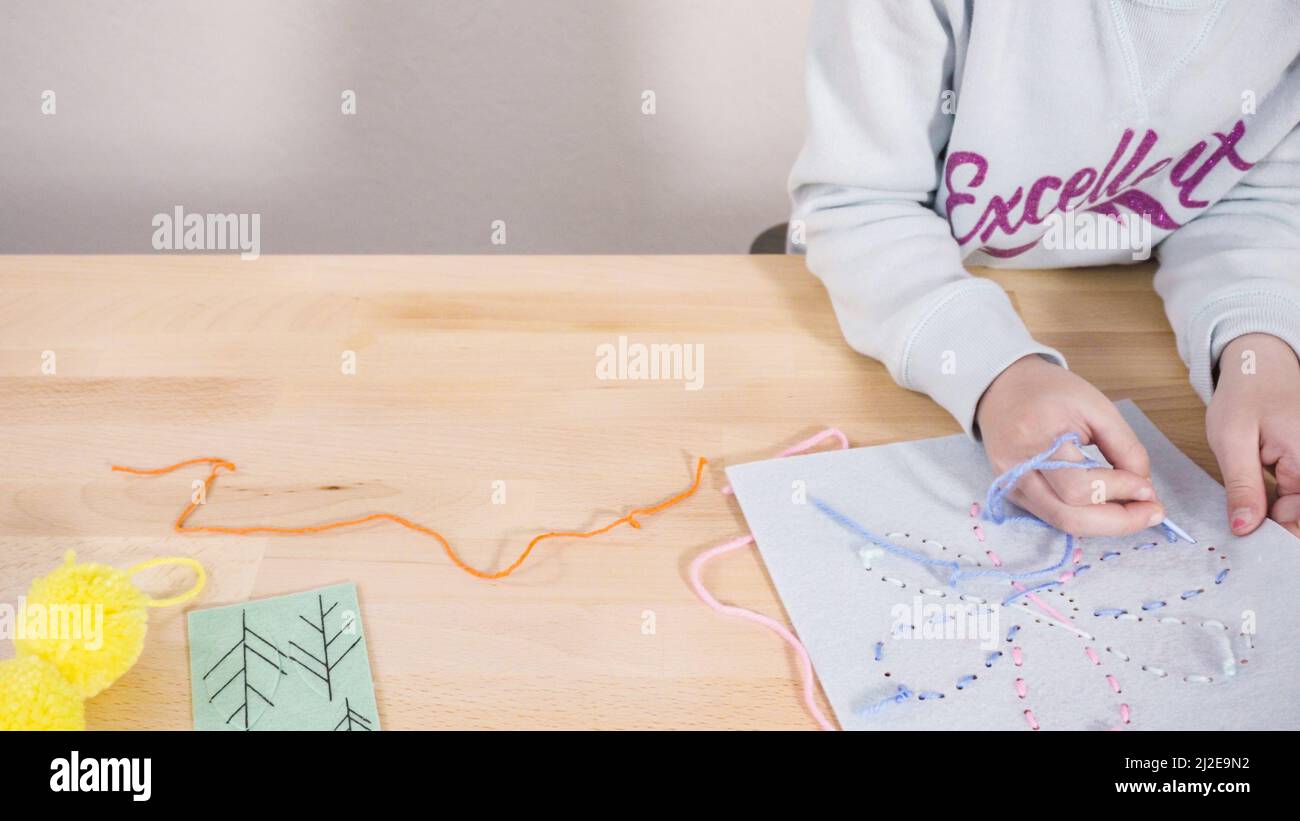 Little girl learning how to sew with sewing craft kit for kids Stock