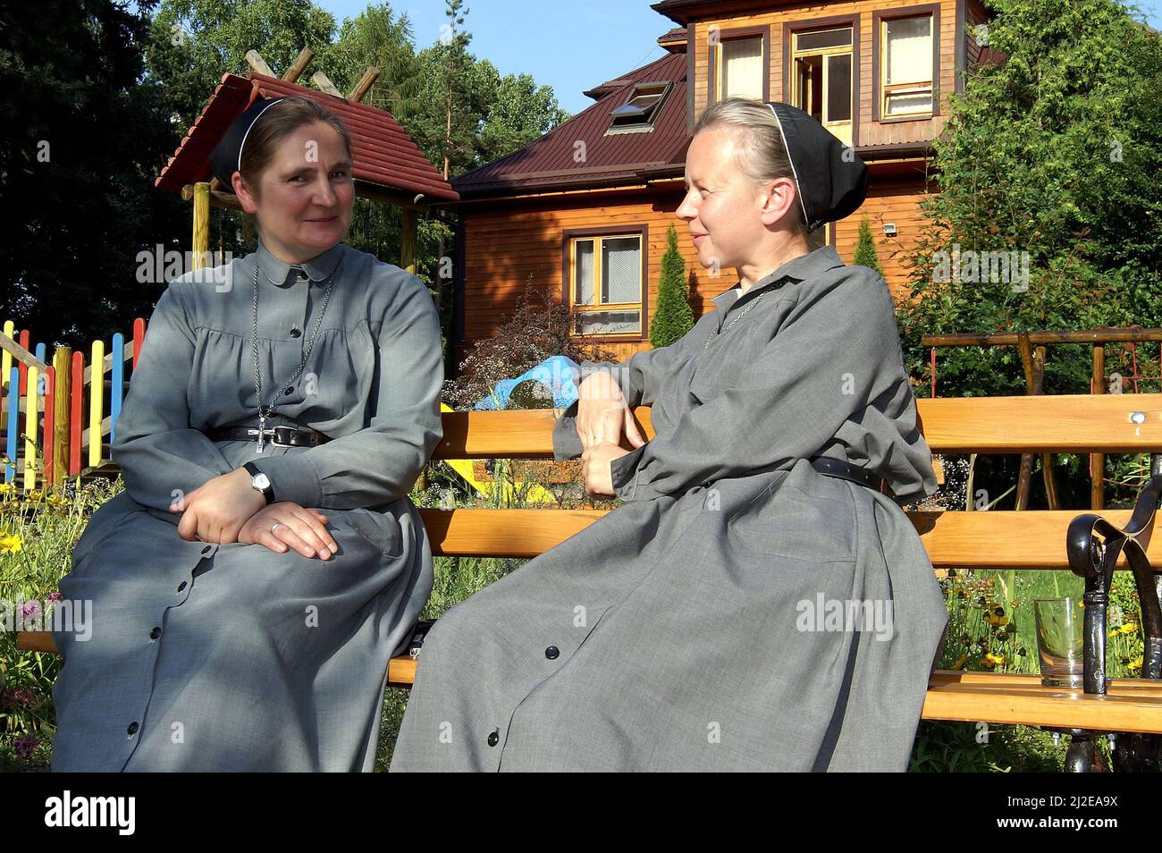Augustów, Poland, Polen, Polska, Two nuns are sitting on a bench and talking. Zwei Nonnen sitzen auf einer Bank und unterhalten sich. Siostry zakonne Stock Photo