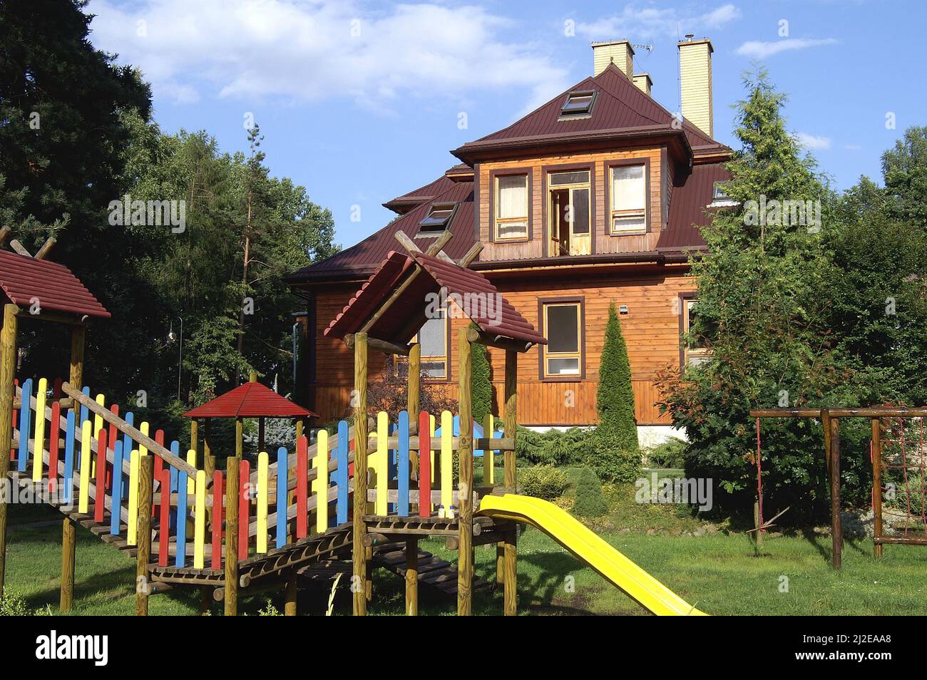 Augustów, Poland, Polen, Polska, Large wooden house surrounded by trees. Großes Holzhaus, umgeben von Bäumen. Duży drewniany dom otoczony drzewami. Stock Photo