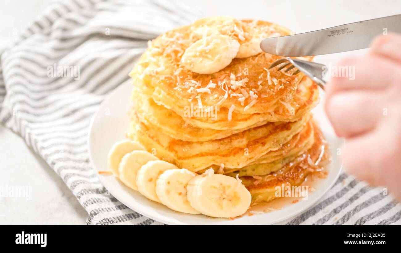 Step by step. Eating freshly baked coconut banana pancakes garnished