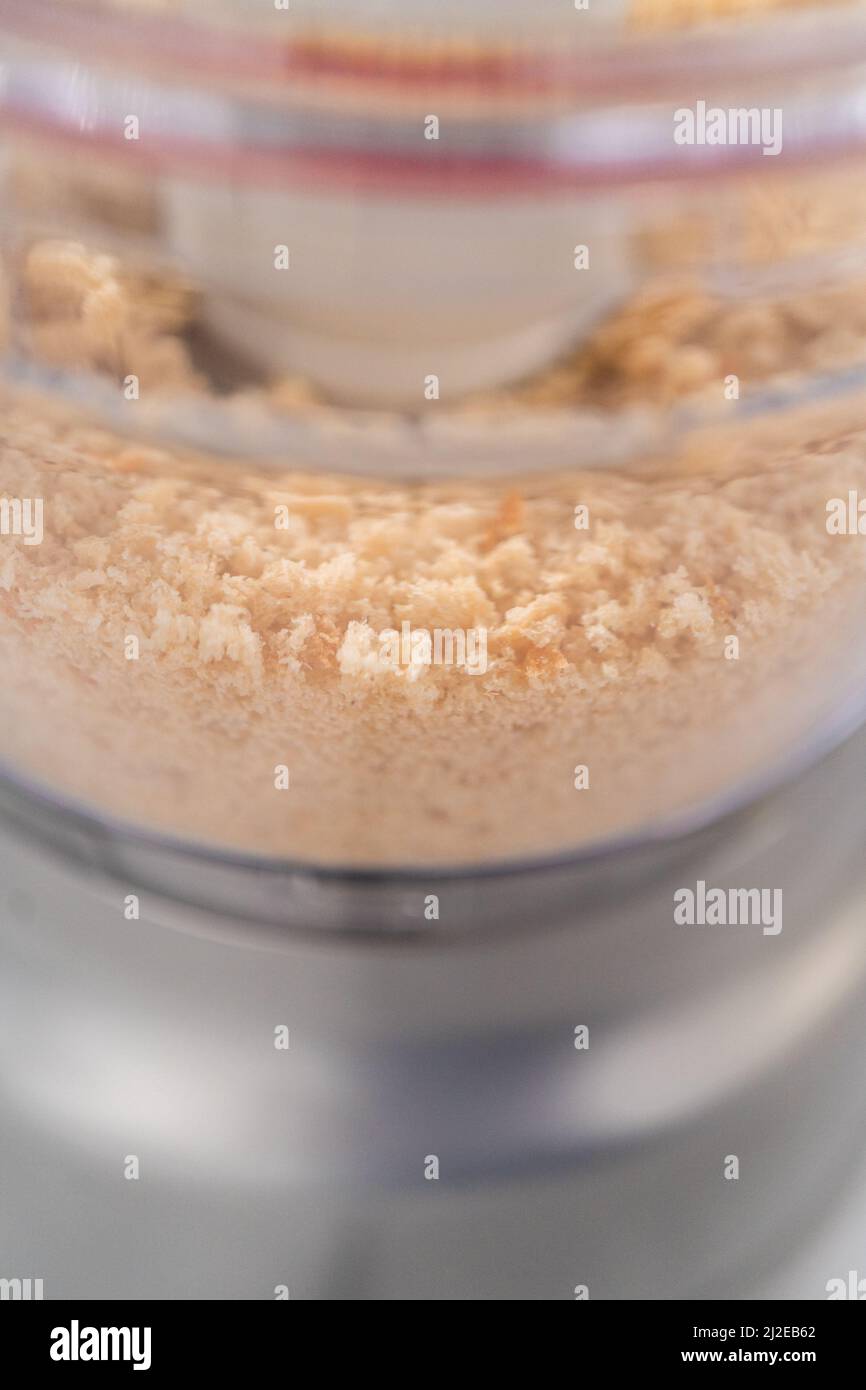 Crumbling stale bread in a food processor to make bread crumbs Stock