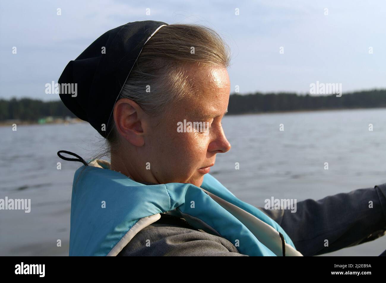 Augustów Poland, Polen, Polska, Portrait of a nun on the background of the lake. Porträt einer Nonne auf dem Hintergrund des Sees. 湖背景上的修女肖像。Zakonnica Stock Photo