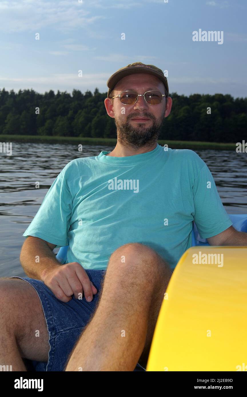 Augustów, Poland, Polen, Polska, A middle-aged man relaxing on a pedalo while swimming on the lake. Mann mittleren Alters ruht auf dem Tretboot. Lato Stock Photo