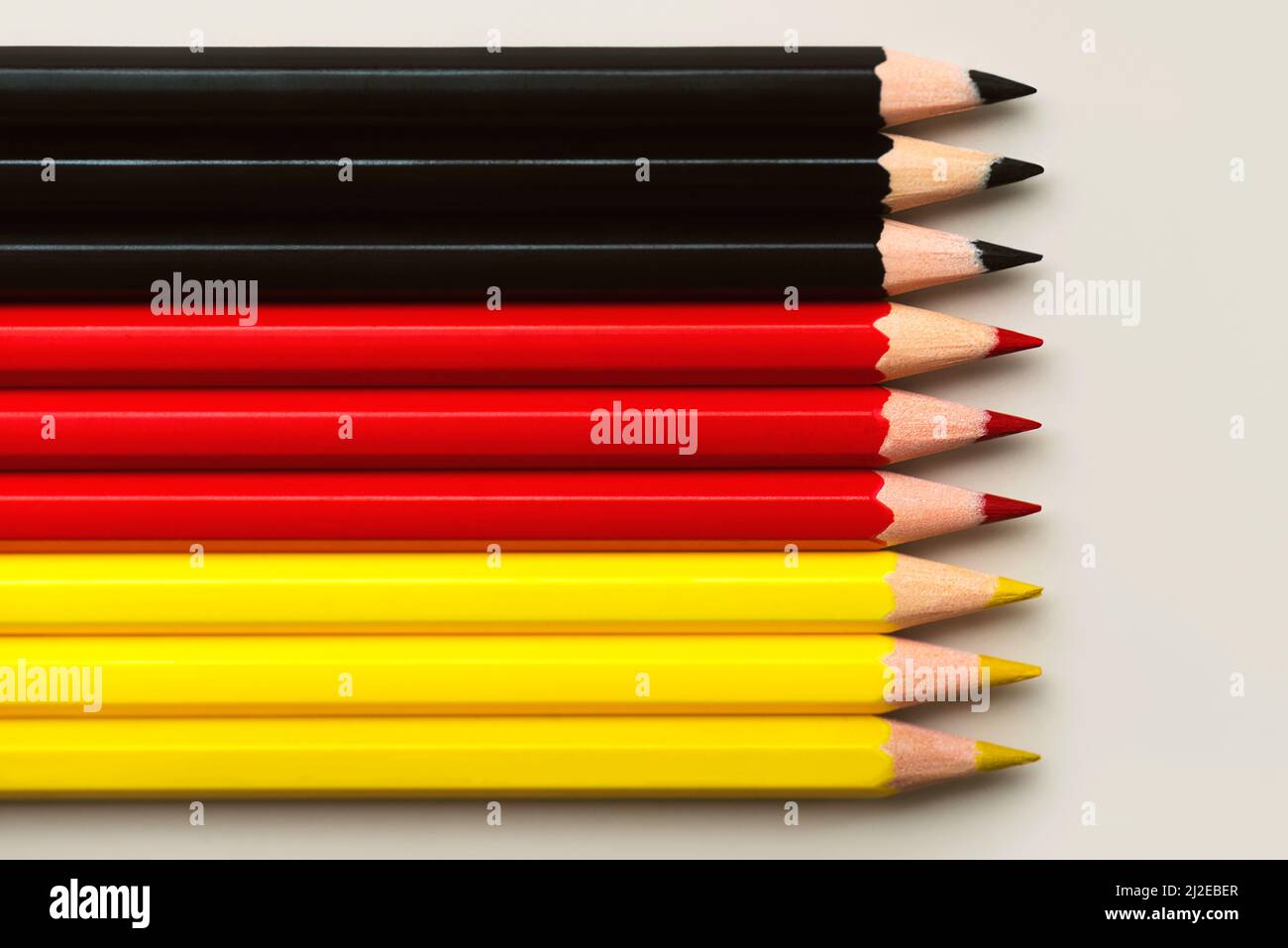 Top view of Germany flag made with black, red and yellow colored pencils with copy space over light background Stock Photo