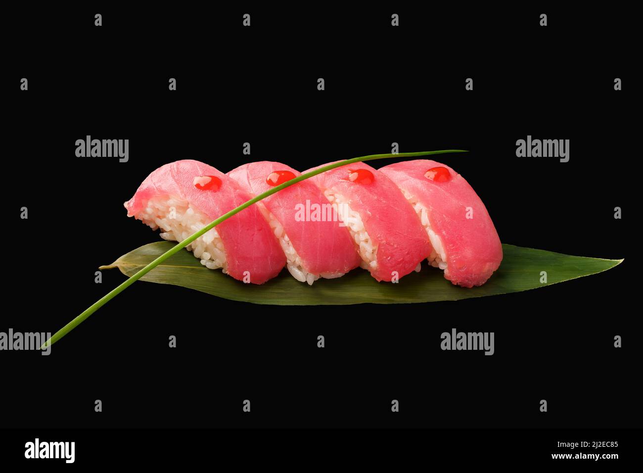 Nigiri sushi tuna with sriracha sauce, chives, banana leaf. japanese