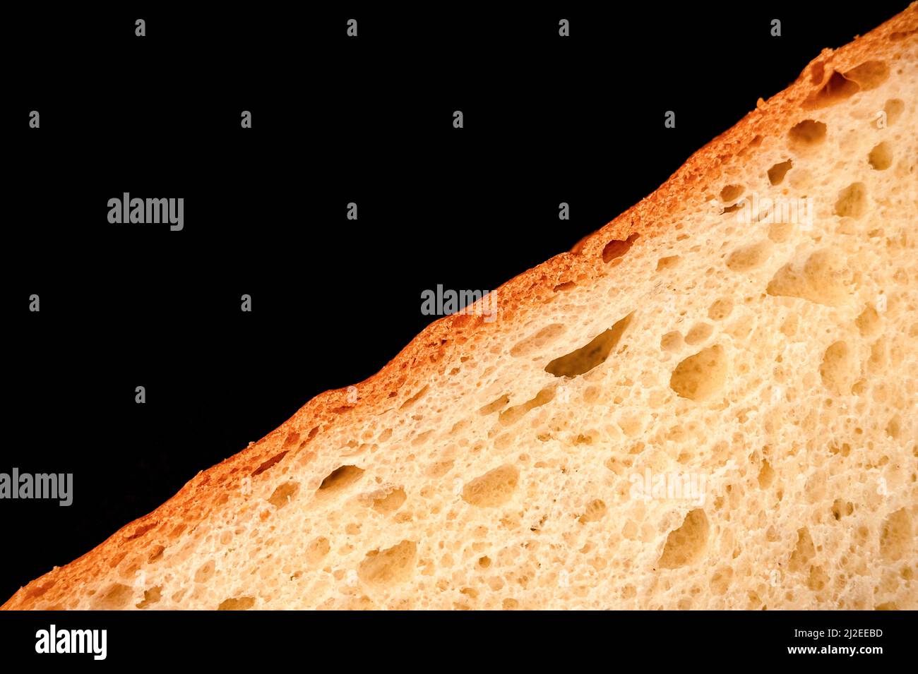slice of white bread close up isolated on a black background. rough
