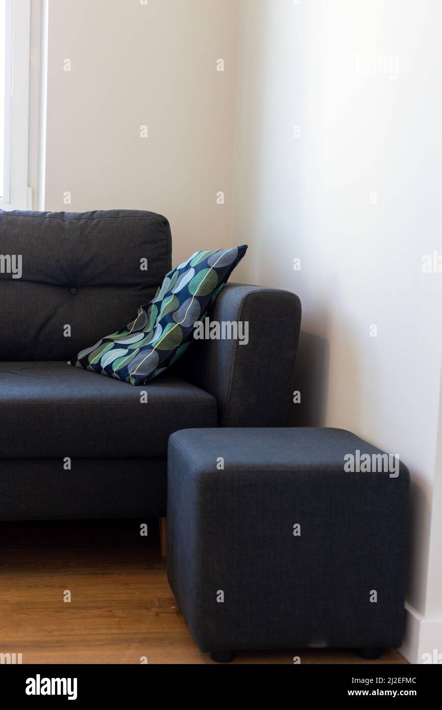 Dark blue sofa with blue and turquoise cushion in a white room Stock Photo