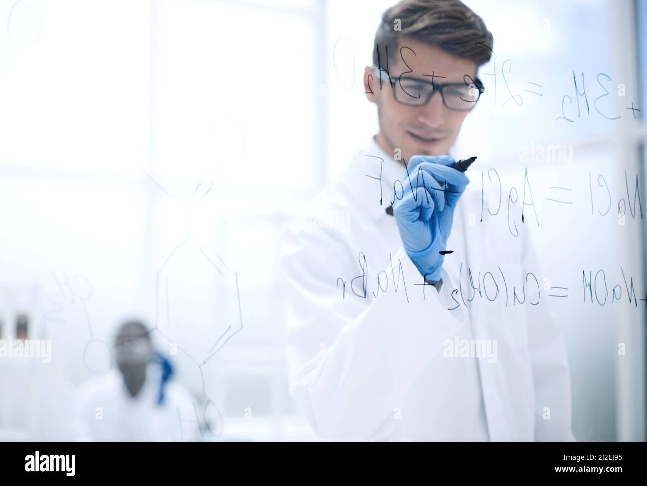 scientist making notes on the glass Board at the time of the experiment Stock Photo