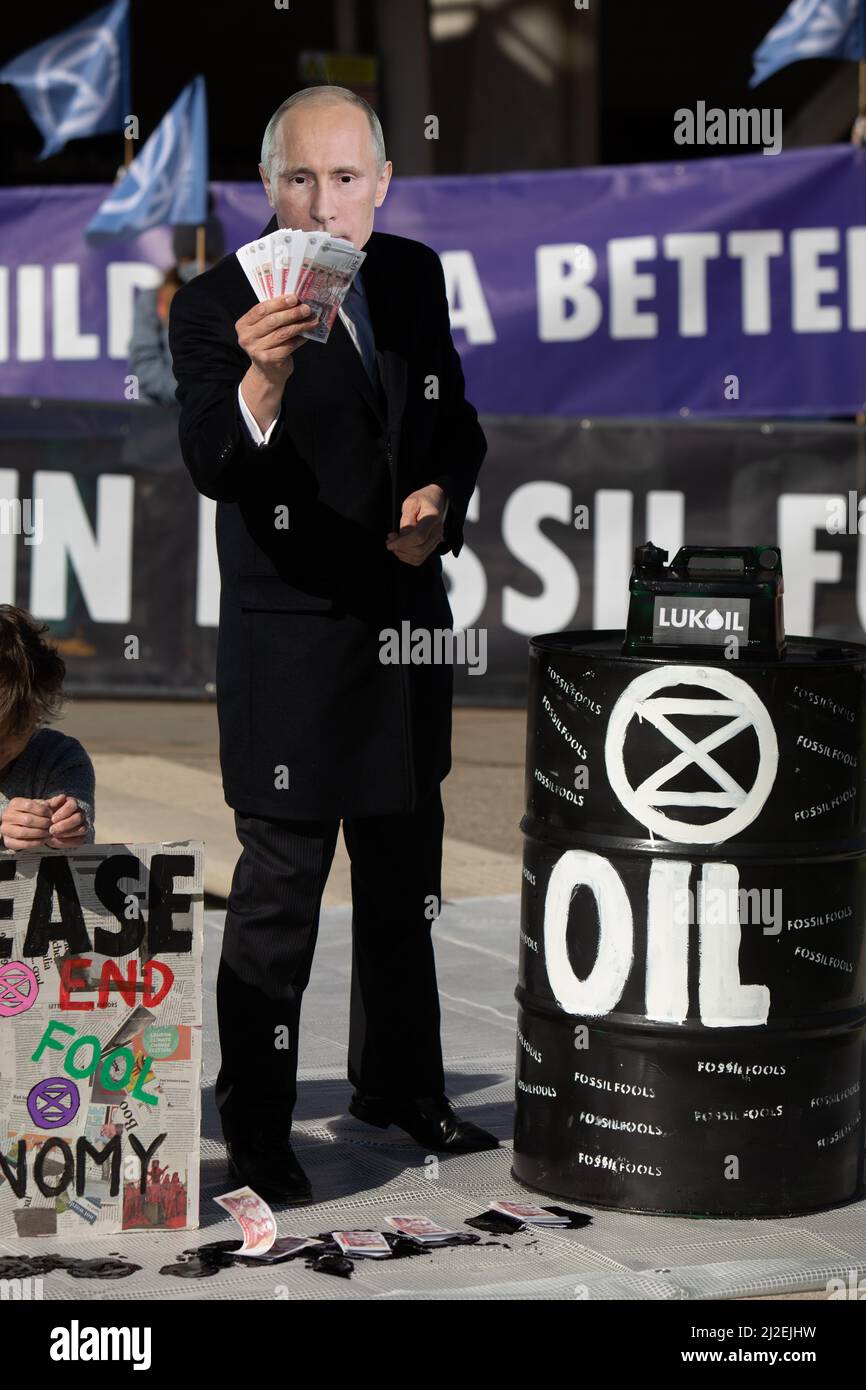 Edinburgh, Scotland, 1 April 2022.  Climate activists from Extinction Rebellion protest outside the Scottish Parliament on day of record energy price rises in UK.  Activists, one wearing a mask of Russian president Vladimir Putin, staged a mock oil spill outside the building to protest the continuing reliance on fossil fuels. Photo credit: Jeremy Sutton-Hibbert/Alamy Live News. Stock Photo