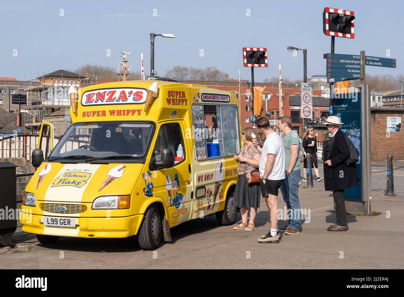 People queue at a van for ice cream on a sunny day at the harbour. Bristol, UK. Credit: Hazel Plater/Alamy Stock Photo